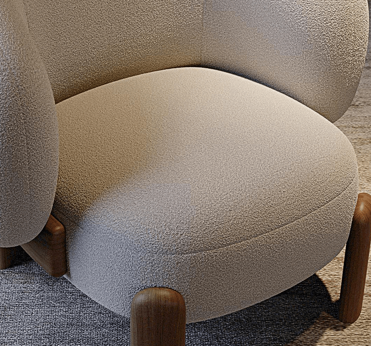 Close-up of a textured beige armchair with wooden legs on a carpeted floor.