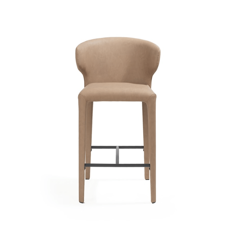 A modern barstool with a curved backrest and seat upholstered in a warm beige fabric, supported by slim wooden legs and a black metal footrest, shown against a plain white background.