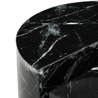 Black marble side table with a curved design on a white background