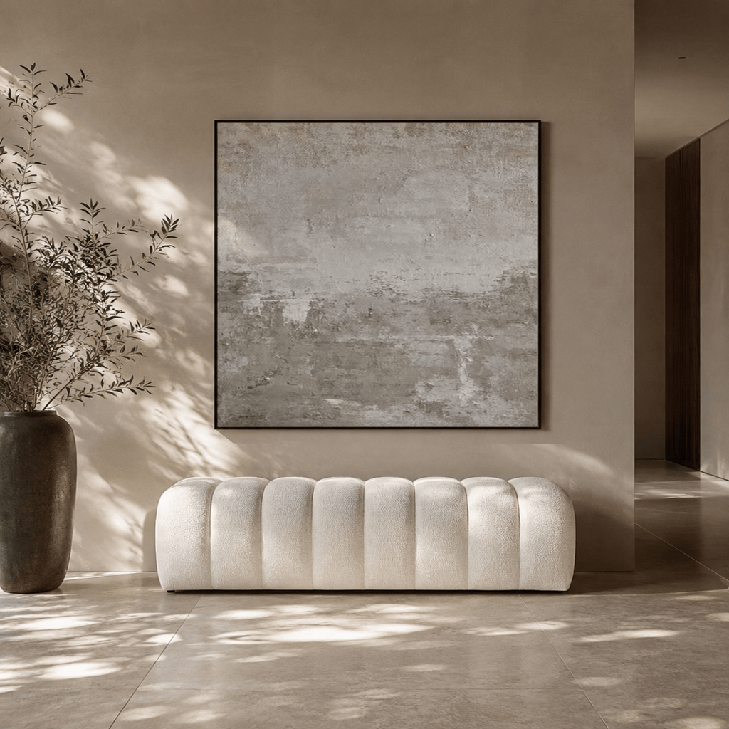 White tufted sofa in a room with a large abstract painting on the wall.