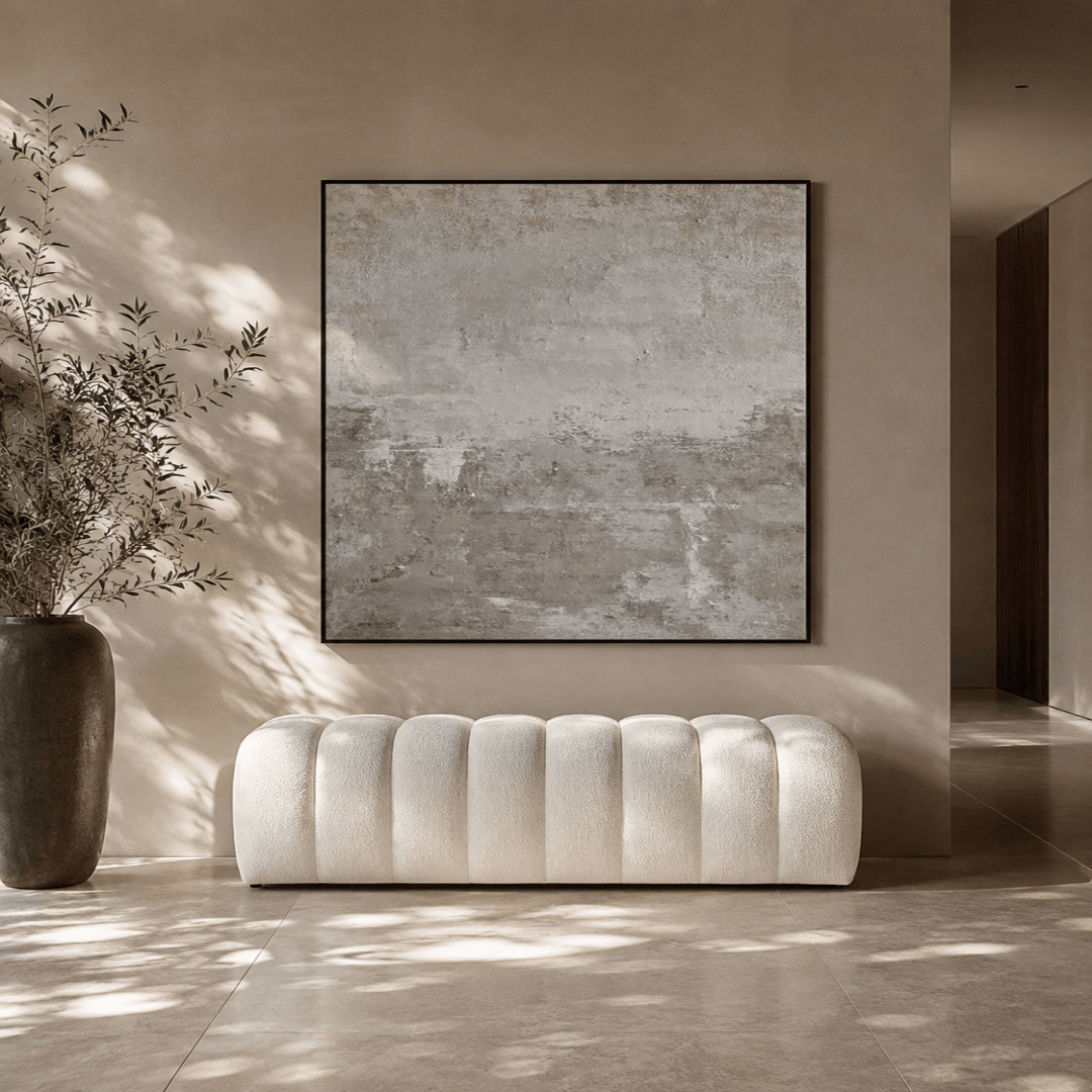 White tufted sofa in a room with a large abstract painting on the wall.