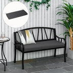 Black metal bench with gray cushion and decorative pillows against a white wooden wall.