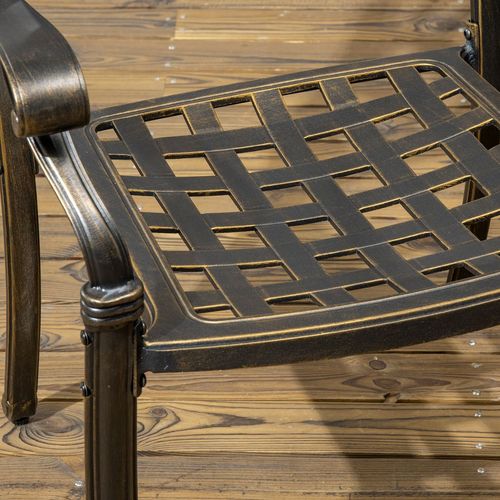 Metal chair seat with lattice design on a wooden surface