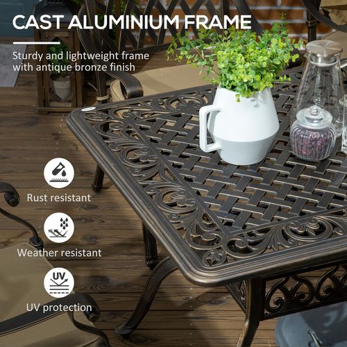 Cast aluminium table with decorative items on a wooden deck, featuring text about its properties.