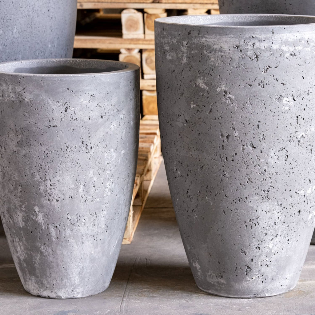 Two large concrete planters on a wooden pallet background