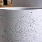 Close-up of a textured gray pot with a blurred background