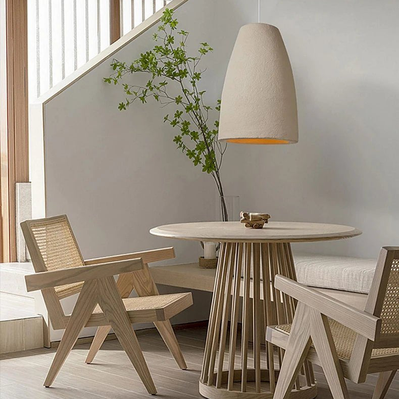 Modern interior with wooden table and chairs, pendant light, and plant.