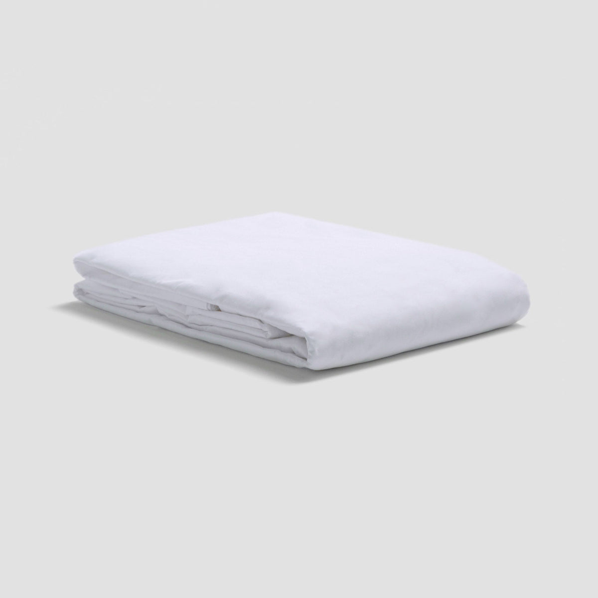 Folded white mattress protector on a light gray background
