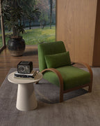 Green armchair with wooden frame in a room with a small table and decorative items.