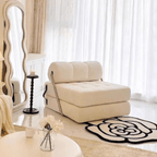 Beige armchair in a stylish living room with white curtains and decorative rug.